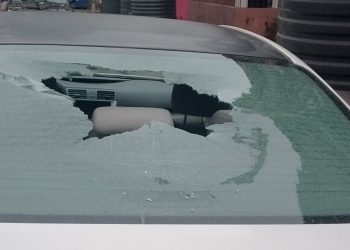 White Toyota Camry with smashed rear window parked in Festac Town, Lagos, showing vandalism damage