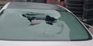 White Toyota Camry with smashed rear window parked in Festac Town, Lagos, showing vandalism damage