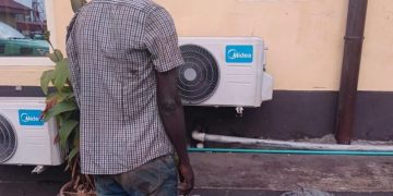 an standing with stolen wire mesh at Lagos KAI office after vandalism arrest