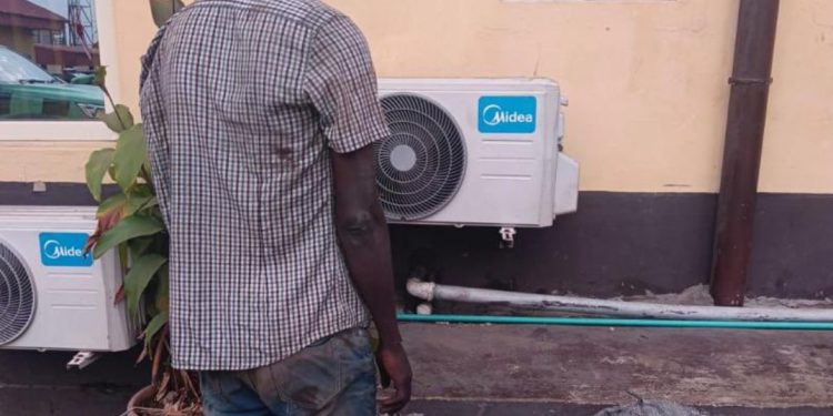 an standing with stolen wire mesh at Lagos KAI office after vandalism arrest