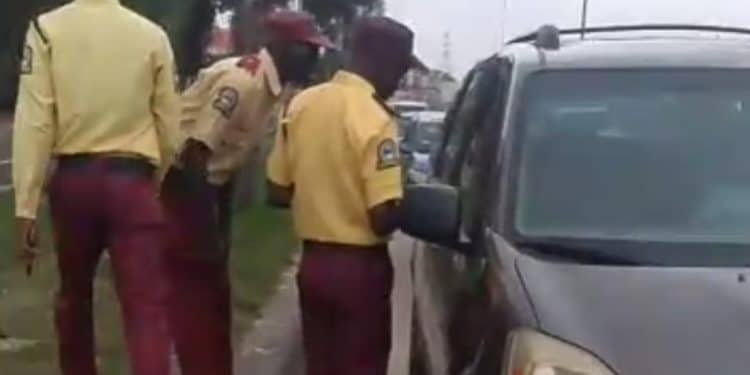 LASTMA officers directing traffic on a busy road in Lagos with the BRT corridor visible.