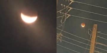 A photograph of a lunar eclipse casting a shadow on the moon, with the Lagos skyline in the foreground.