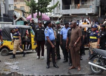 Police officers managing a crowd at a market in Lagos, Nigeria.