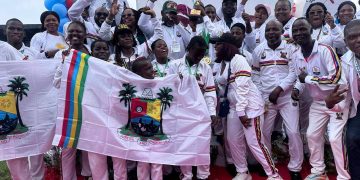 A group of jubilant young athletes from Team Lagos celebrates with their gold medals and a trophy.