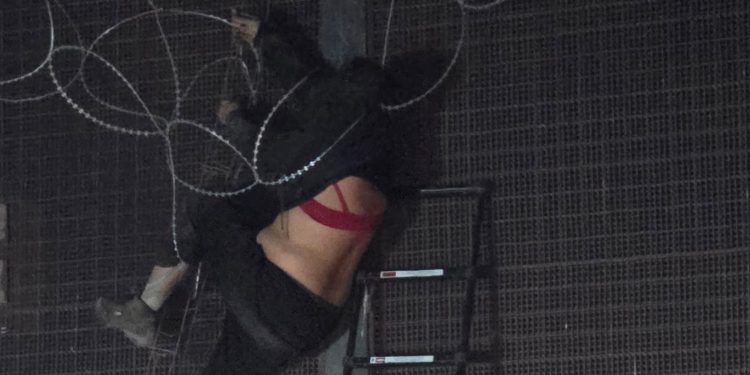 U.S. Border Patrol agents cutting concertina wire to free an individual trapped on the border.