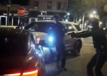 Police dashcam footage of a car collision and officer with a gun.