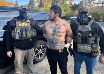 Unmarked police cars and officers outside an apartment building after a high-risk arrest.