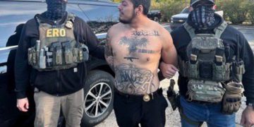 Unmarked police cars and officers outside an apartment building after a high-risk arrest.