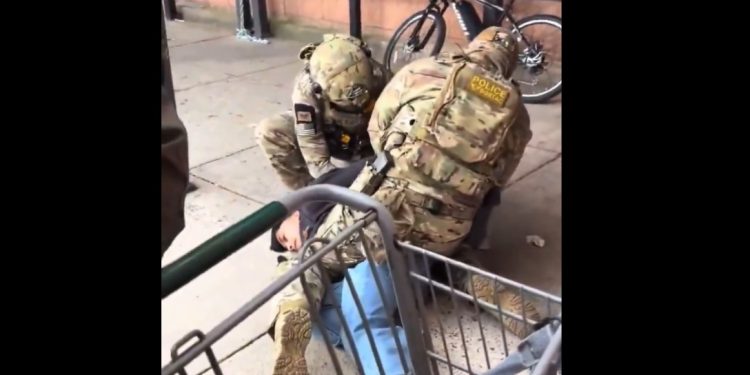 Commander Gregory K. Bovino speaking in front of federal agency logos.