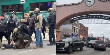 Chicago Police officers standing near federal agents during an arrest on a busy street.